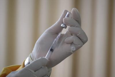 Health care worker filling up a syringe with vaccine